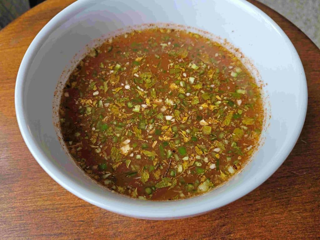 Make the marinade by mixing the: beer, serrano chile, spices and onions.